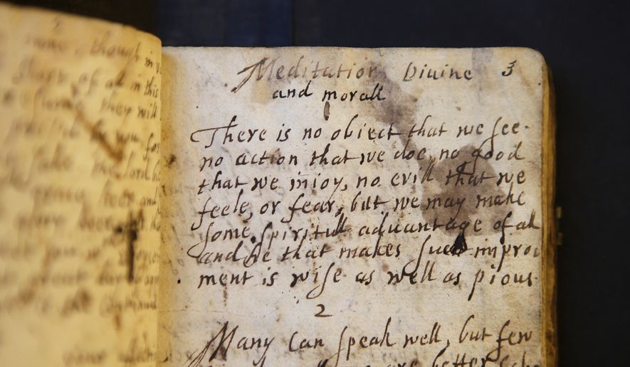 In this Wednesday, March 20, 2019, photo provided by the Board of Trustees of Stevens Memorial Library, a handwritten manuscript called "Meditations Divine and Moral," by 17th century poet Anne Bradstreet, rests on a table at the Houghton Library on the campus of Harvard University, in Cambridge, Mass. Bradstreet was the North American continent's first published poet. Her actual burial place is not known. (Courtesy of Board of Trustees of Stevens Memorial Library via AP)