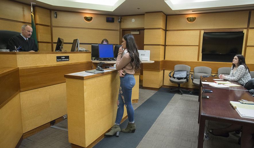 Judge Darvin Zimmerman, left, listens to comments from survivor Jordan Holgerson, center, as defendant Tay'Lor Smith, right, looks on during Smith's sentencing at the Clark County Courthouse in Vancouver, Wash., on Wednesday, March 27, 2019. Smith pleaded guilty to pushing her friend Holgerson from a bridge at a popular swimming area near Vancouver, in August. (Amanda Cowan/The Columbian via AP)