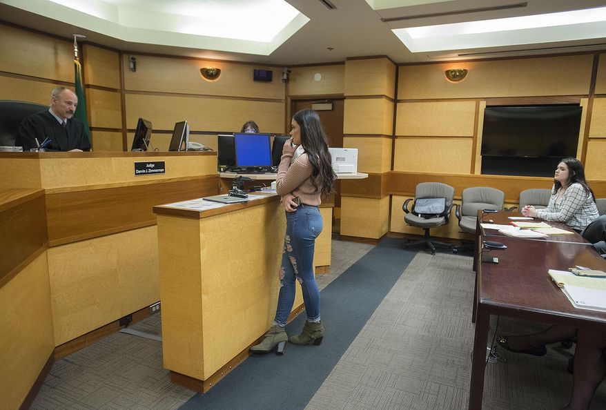 Judge Darvin Zimmerman, left, listens to comments from survivor Jordan Holgerson, center, as defendant Tay'Lor Smith, right, looks on during Smith's sentencing at the Clark County Courthouse in Vancouver, Wash., on Wednesday, March 27, 2019. Smith pleaded guilty to pushing her friend Holgerson from a bridge at a popular swimming area near Vancouver, in August. (Amanda Cowan/The Columbian via AP)