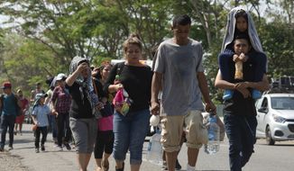 Central American migrants, part of the caravan hoping to reach the U.S. border, move on a road in Tapachula, Chiapas State, Mexico, Thursday, March 28, 2019. A caravan of about 2,500 Central Americans and Cubans is currently making its way through Mexico&#39;s southern state of Chiapas. (AP Photo/Isabel Mateos)
