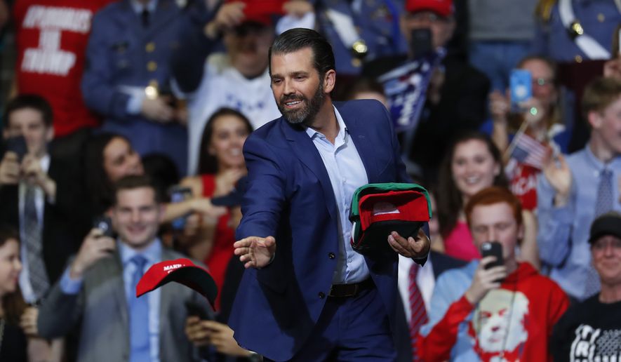 Donald Trump Jr. tosses hats to the audience during a rally in Grand Rapids, Mich., Thursday, March 28, 2019. (AP Photo/Paul Sancya)