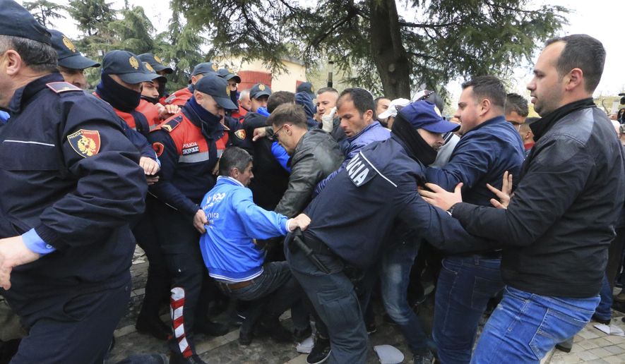 Protesters clash with police front of the Albanian parliament building in Tirana, on Thursday, March 28, 2019. Albanian opposition protesters have repeated attempts to enter the parliament by force in their protest asking for the government's resignation and an early election.(AP Photo/ Hektor Pustina)