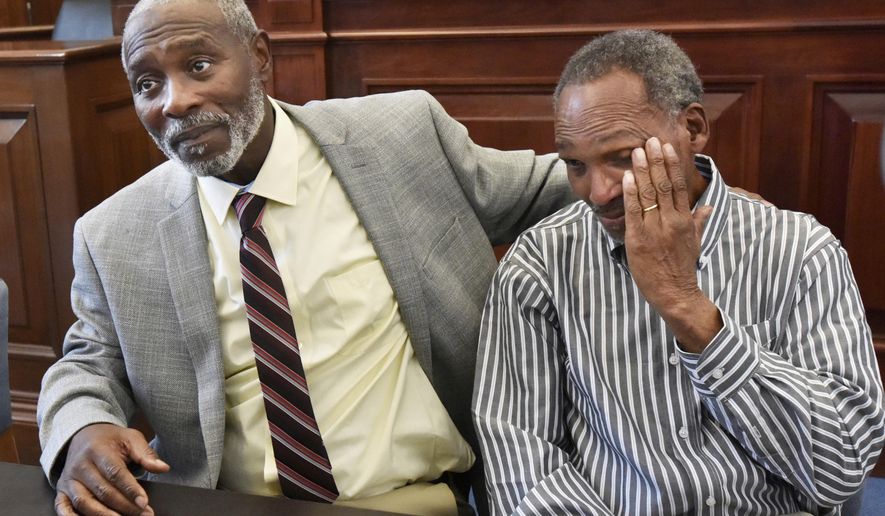 Nathan Myers, left, embraces his uncle, Clifford Williams, during a news conference after their 1976 murder convictions were overturned Thursday, March 28, 2019 in Jacksonville, Fla. The order to vacate the convictions originated from the first ever conviction integrity review unit set up by State Attorney Melissa Nelson. (Will Dickey/The Florida Times-Union via AP)