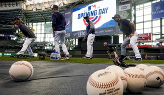 Milwaukee Brewers players warm up before an Opening Day baseball game against the St. Louis Cardinals Thursday, March 28, 2019, in Milwaukee. (AP Photo/Morry Gash)