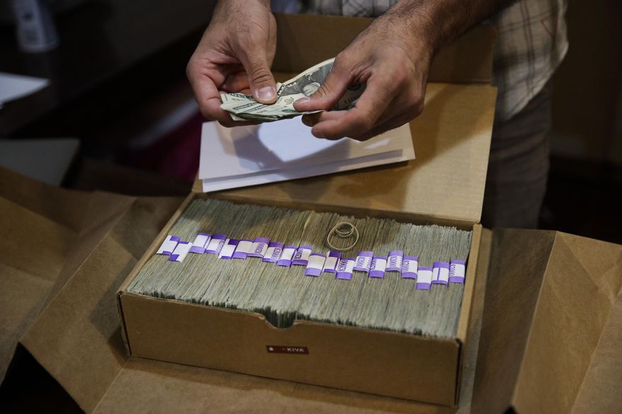 In this June 27, 2017, file photo, the proprietor of a medical marijuana dispensary prepares his monthly tax payment, more than $40,000 in cash, at his Los Angeles store. (AP Photo/Jae C. Hong, File)