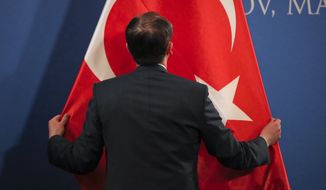 A man sets up a Turkish flag before press statements by Turkish Vice President Fuat Oktay and Romanian Prime Minister Viorica Dancila in Snagov, Romania, Friday, March 29, 2019. (AP Photo/Vadim Ghirda) 