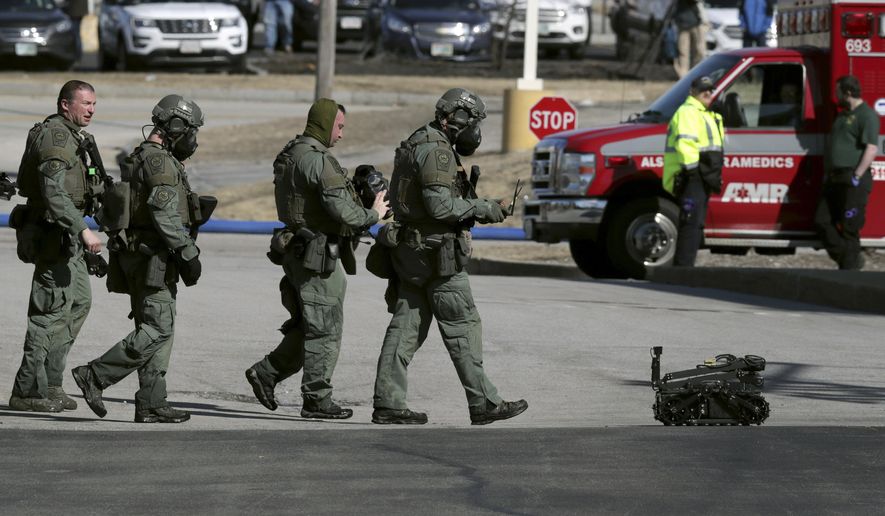 Police and a robotic device exit the Quality Inn on Thursday, March 28, 2019, in Manchester, N.H., after a standoff was resolved. Two people had barricaded themselves in a first-floor room after one man was shot and killed there Wednesday night by police after he engaged Drug Enforcement Administration agents and police. (AP Photo/Charles Krupa)
