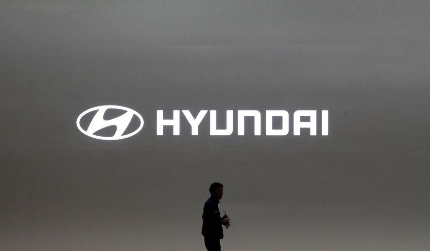 FILE- In this March 28, 2019, file photo a journalist passes by the logo of Hyundai Motor during a media preview of the Seoul Motor Show in Goyang, South Korea. Hyundai has found a new problem that can cause its car engines to fail or catch fire, issuing yet another recall to fix problems that have affected more than 6 million vehicles since 2015. (AP Photo/Ahn Young-joon, File)