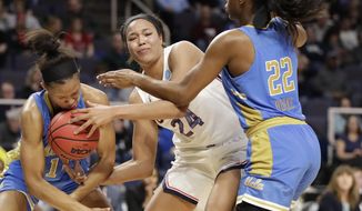 UCLA forward Lajahna Drummer, left, gets the basketball to her face as she tries to steal the ball from Connecticut forward Napheesa Collier (24) with UCLA guard Kennedy Burke (22) defending during the first half of a regional semifinal game in the NCAA women&#x27;s college basketball tournament, Friday, March 29, 2019, in Albany, N.Y. (AP Photo/Kathy Willens)