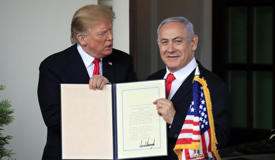 Visiting Israeli Prime Minister Benjamin Netanyahu and President Donald Trump hold up the signed proclamation recognizing Israel's sovereignty over the Golan Heights as Netanyahu leaves the White House in Washington, Monday, March 25, 2019. (AP Photo/Manuel Balce Ceneta)