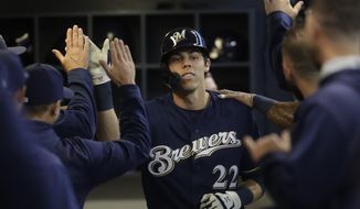 Milwaukee Brewers&#39; Christian Yelich is congratulated after hitting a home run during the first inning of a baseball game against the St. Louis Cardinals Saturday, March 30, 2019, in Milwaukee. (AP Photo/Morry Gash)