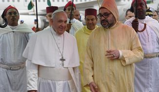 Pope Francis, left is greeted by Morocco&#39;s King Mohammed VI, centre upon disembarking from his plane at Rabat-Sale International Airport near the capital Rabat, Saturday, March 30, 2019. Pope Francis has arrived in Morocco for a trip aimed at highlighting the North African nation&#39;s tradition of Christian-Muslim ties, while also letting him show solidarity with migrants at Europe&#39;s door and tend to a tiny Catholic flock. (Fadel Senna/Pool Photo via AP)