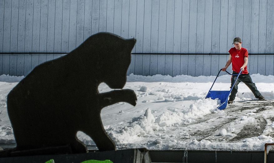 FILE - In this March 13, 2019 file photo Scotty Charles uses a scoop to remove snow from the roof of Bootleggers Beverage & Redemption Center in Lisbon, Maine. Snowfall has largely ceased for the season in Lisbon, the rest of southern Maine and in northern Maine, too. The National Weather Service reports that Caribou measured 154 inches of snow for the season through March, about 44 inches shy of the record. Meteorologist Rich Norton said Caribou was on a record pace for snowfall until the snowfall slowed this month. (Russ Dillingham/Sun Journal via AP, File)