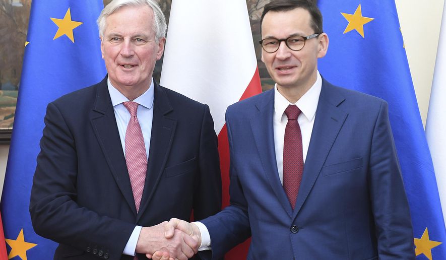 European Union Brexit negotiator Michel Barnier,left, and Poland's Prime Minister Mateusz Morawiecki, right, shake hands during a news conference following their talks on possible scenarios for Britain's departure from the 28-member bloc in Warsaw, Poland, Friday, March 29, 2019. Morawiecki said that if twice-rejected divorce deal is not approved Friday, the EU is open to Britain's requests for further extension of the departure process for up to 12 months. (AP Photo/Stringer)