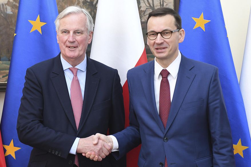 European Union Brexit negotiator Michel Barnier,left, and Poland's Prime Minister Mateusz Morawiecki, right, shake hands during a news conference following their talks on possible scenarios for Britain's departure from the 28-member bloc in Warsaw, Poland, Friday, March 29, 2019. Morawiecki said that if twice-rejected divorce deal is not approved Friday, the EU is open to Britain's requests for further extension of the departure process for up to 12 months. (AP Photo/Stringer)