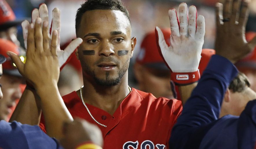 Boston Red Sox's Xander Bogaerts gets high-fives in the dugout after scoring during the seventh inning of the team's spring training baseball game against the Chicago Cubs on Monday, March 25, 2019, in Mesa, Ariz. (AP Photo/Sue Ogrocki)