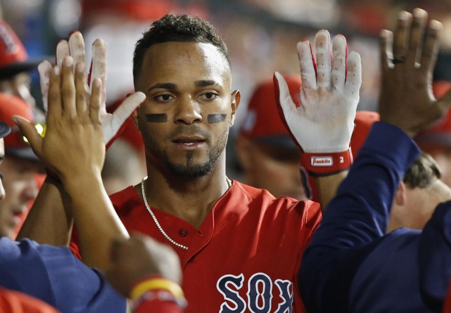 Boston Red Sox's Xander Bogaerts gets high-fives in the dugout after scoring during the seventh inning of the team's spring training baseball game against the Chicago Cubs on Monday, March 25, 2019, in Mesa, Ariz. (AP Photo/Sue Ogrocki)