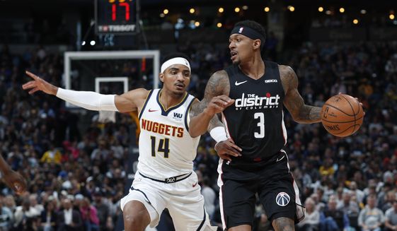 Washington Wizards guard Bradley Beal, right, drives past Denver Nuggets guard Gary Harris in the first half of an NBA basketball game Sunday, March 31, 2019, in Denver. (AP Photo/David Zalubowski)