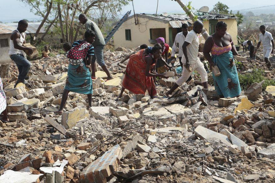 Women and men pick up bricks from a collapsed house to build another structure in Beira, Mozambique, Sunday, March, 31, 2019. Cholera cases among cyclone survivors in Mozambique have jumped to 271, authorities said. So far no cholera deaths have been confirmed, the report said. Another Lusa report said the death toll in central Mozambique from the cyclone that hit on March 14 had inched up to 501. Authorities have warned the toll is highly preliminary as flood waters recede and reveal more bodies. (AP Photo/Tsvangirayi Mukwazhi)