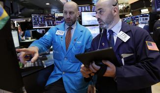 FILE- In this March 18, 2019, file photo specialist Meric Greenbaum, left, and trader Fred DeMarco work on the floor of the New York Stock Exchange. The U.S. stock market opens at 9:30 a.m. EDT on Monday, April 1. (AP Photo/Richard Drew, File)