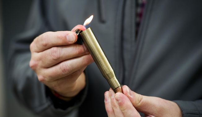 David Johnston, TSA&#x27;s social media director, displays a lighter mounted inside of a bullet casing which was confiscated from a passenger at a Transportation Security Administration (TSA) checkpoint at Dulles International Airport in Dulles, Va., Tuesday, March 26, 2019. TSA’s social media presence has been something of a model for other federal agencies — striking a tone is humorous, but still gives travelers informational dos and don’ts. (AP Photo/Cliff Owen)