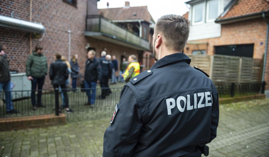 FILE -- A police officer attends a raid against fraud crime in Wriedel, Germany, Wednesday, March 27, 2019. New government statistics show overall crime in Germany, including violent offenses, dropped in 2018 while clearance rates continue to climb German Interior Minister Horst Seehofer said on Tuesday. (Philipp Schulze/dpa via AP, file)