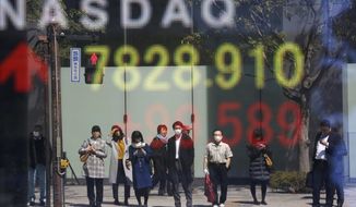 People are reflected on the electronic board of a securities firm in Tokyo, Tuesday, April 2, 2019. Asian stock prices followed Wall Street higher on Tuesday on encouraging global economic data.(AP Photo/Koji Sasahara)