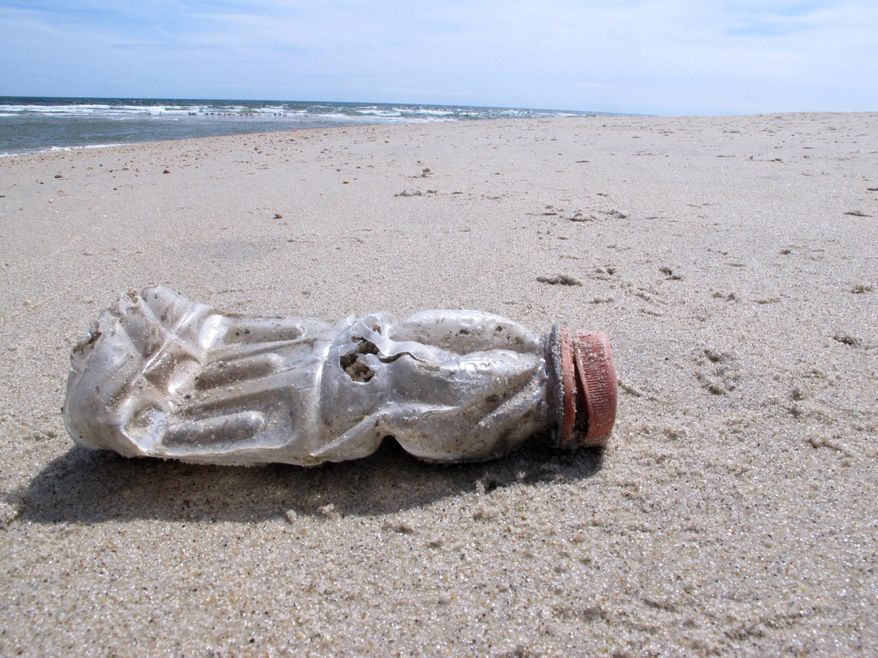 A discarded plastic bottle lies on the beach at Sandy Hook, N.J., on Tuesday, April 2, 2019, the same day as a report released by the environmental group Clean Ocean Action found that volunteers picked up more than 450,000 pieces of litter from New Jersey's coastline last year. (AP Photo/Wayne Parry) ** FILE **