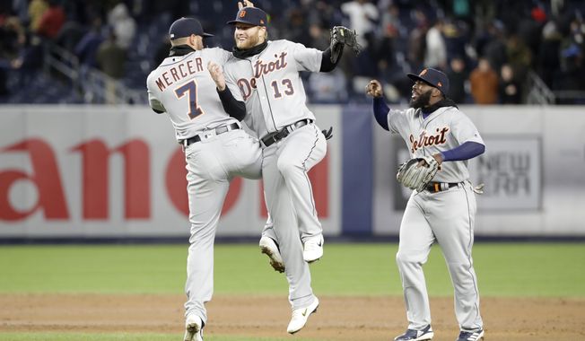 Detroit Tigers shortstop Jordy Mercer (7) and Tigers center fielder Dustin Peterson (13) celebrate by going airborne as Detroit Tigers second baseman Josh Harrison (1) joins them in celebrating after the Tigers defeated the New York Yankees 3-1 in a baseball game, Tuesday, April 2, 2019, in New York. (AP Photo/Kathy Willens)