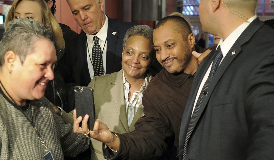 Chicago Mayor-elect Lori Lightfoot, center left, poses for a photo as she greets commuters, Wednesday, April 3, 2019, at the Clark/Lake CTA Station in Chicago. Lightfoot, a former federal prosecutor who&#39;d never been elected to public office, defeated Cook County Board President and longtime City Council member Toni Preckwinkle on Tuesday with backing from voters across the city. (Victor Hilitski/Chicago Sun-Times via AP)