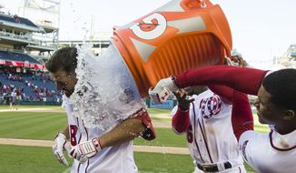 Washington Nationals&#39; Jake Noll, left, gets doused by Victor Robles and Juan Soto, right, after a baseball game against the Philadelphia Phillies at Nationals Park, Wednesday, April 3, 2019, in Washington. Noll drew a walk to force in the winning run. The Nationals won 9-8. (AP Photo/Alex Brandon)