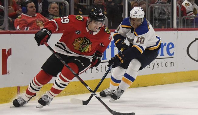 Chicago Blackhawks defenseman Dennis Gilbert (39) is defended by St. Louis Blues center Brayden Schenn (10) during the second period of an NHL hockey game Wednesday, April 3, 2019, in Chicago. (AP Photo/David Banks)