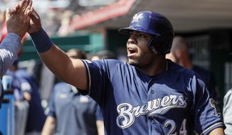 Milwaukee Brewers&#39; Jesus Aguilar celebrates in the dugout after scoring on an RBI single by Manny Pina off Cincinnati Reds starting pitcher Luis Castillo in the second inning of a baseball game, Wednesday, April 3, 2019, in Cincinnati. (AP Photo/John Minchillo)