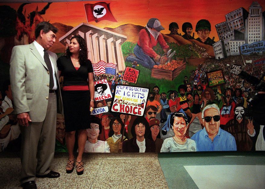 FILE - In this May 9, 2000 file photo, Mexican opposition candidate Cuauhtemoc Cardenas, left, of the Democratic Revolution Party, poses for a photo with Candy Angel, right, president of the Mexican American student group, MEChA, during a visit to the Chicano Studies Department at California State University-Northridge in Los Angeles. MEChA, a Mexican American student group founded 50 years ago, is considering a name change, highlighting the divisions between older civil rights advocates and younger activists. Student leaders voted Sunday, March 31, 2019, in Los Angeles to drop the reference to “Chicano” and “Aztlan” from the group's full name Movimiento Estudiantil Chicanx de Aztlan. (AP Photo/Damian Dovarganes, File)