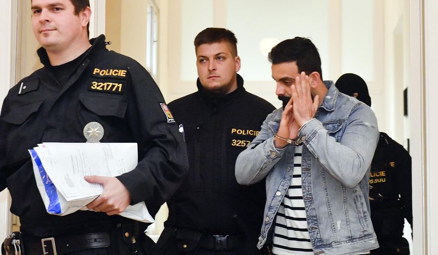 Iraqi Ammar Raheem Mahmod Mahmod, right, suspected of terrorism is escorted at the Municipal Court in Prague, Friday, March 29, 2019. The court ruled that Iraqi terror suspects Amar Rahim Mahmoud Mahmoud and Riyam Shukri Sali Badri, who were arrested at Prague airport on Wednesday, be remanded in custody, and both agreed with the extradition to Austria, Prague Municipal State Attorney's Office spokesman said today. (Vit Simanek/CTK via AP)