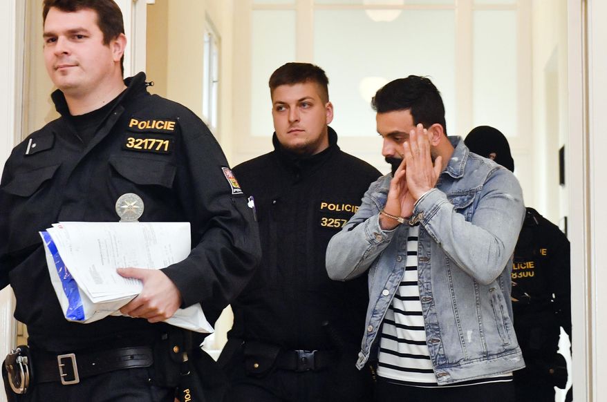 Iraqi Ammar Raheem Mahmod Mahmod, right, suspected of terrorism is escorted at the Municipal Court in Prague, Friday, March 29, 2019. The court ruled that Iraqi terror suspects Amar Rahim Mahmoud Mahmoud and Riyam Shukri Sali Badri, who were arrested at Prague airport on Wednesday, be remanded in custody, and both agreed with the extradition to Austria, Prague Municipal State Attorney's Office spokesman said today. (Vit Simanek/CTK via AP)