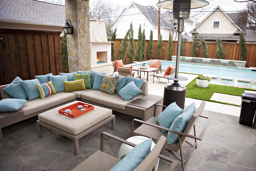 This undated photo shows an outdoor space at a home in Texas designed by Abbe Fenimore, founder of Studio Ten 25. With the addition of an outdoor fireplace and a standing space heater, a backyard can be focused on the swimming pool during the summer but be enjoyed even in cooler weather. (Melanie Johnson Photography/Abbe Fenimore via AP)