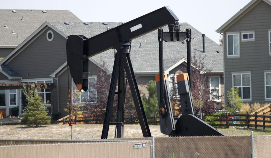 FILE--In this Aug. 16, 2018, file photo, a pump jack works in a recently constructed residential development in Frederick, Colo. On Wednesday, April 3, 2019, the Colorado Legislature gave final approval to a bill that would dramatically change how the state regulates the oil and gas industry, shifting the focus from encouraging production to protecting public health and the environment. The bill now goes to Democratic Gov. Jared Polis, who is expected to sign it. (AP Photo/David Zalubowski, File)