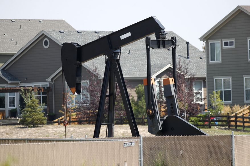 FILE--In this Aug. 16, 2018, file photo, a pump jack works in a recently constructed residential development in Frederick, Colo. On Wednesday, April 3, 2019, the Colorado Legislature gave final approval to a bill that would dramatically change how the state regulates the oil and gas industry, shifting the focus from encouraging production to protecting public health and the environment. The bill now goes to Democratic Gov. Jared Polis, who is expected to sign it. (AP Photo/David Zalubowski, File)
