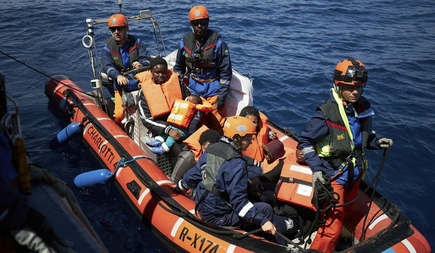 This April 3, 2019 photo shows migrants on a rubber dinghy rescued by the Sea-Eye rescue ship in the waters off Libya. The humanitarian ship Sea-Eye with 64 rescued migrants aboard was stuck at sea on Thursday as Italy and Malta refuse it safe harbor as their refusal set the stage for another Mediterranean standoff that can only be resolved if European governments agree to accept the asylum-seekers. (Fabian Heinz/Sea-eye.org via AP)