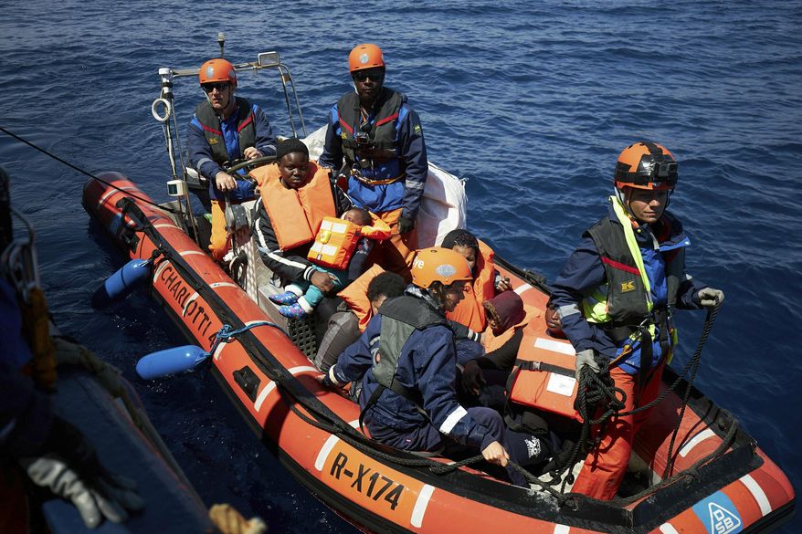 This April 3, 2019 photo shows migrants on a rubber dinghy rescued by the Sea-Eye rescue ship in the waters off Libya. The humanitarian ship Sea-Eye with 64 rescued migrants aboard was stuck at sea on Thursday as Italy and Malta refuse it safe harbor as their refusal set the stage for another Mediterranean standoff that can only be resolved if European governments agree to accept the asylum-seekers. (Fabian Heinz/Sea-eye.org via AP)