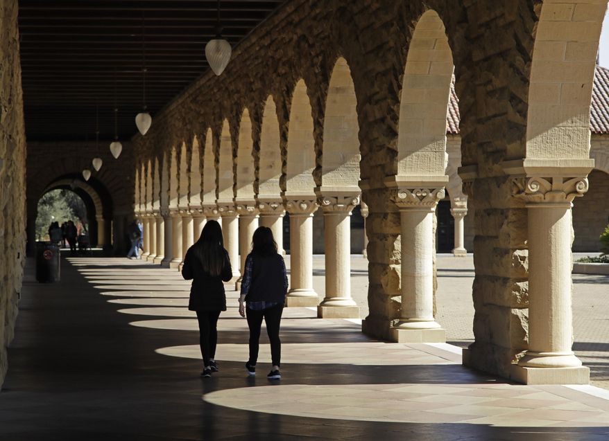 In this March 14, 2019, file photo students walk on the Stanford University campus in Santa Clara, Calif. Before student loans, people who couldn’t afford to go to college usually didn’t. Even though tuition was cheaper, it was still cost-prohibitive for many, who turned to solutions such as working through school, getting help from their parents or finding scholarships. (AP Photo/Ben Margot, File) **FILE**