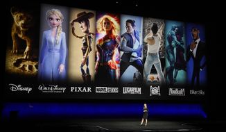 Characters from Disney and Fox movies are displayed behind Cathleen Taff, president of distribution, franchise management, business and audience insight for Walt Disney Studios during the Walt Disney Studios Motion Pictures presentation at CinemaCon 2019, the official convention of the National Association of Theatre Owners (NATO) at Caesars Palace, Wednesday, April 3, 2019, in Las Vegas. (Photo by Chris Pizzello/Invision/AP)