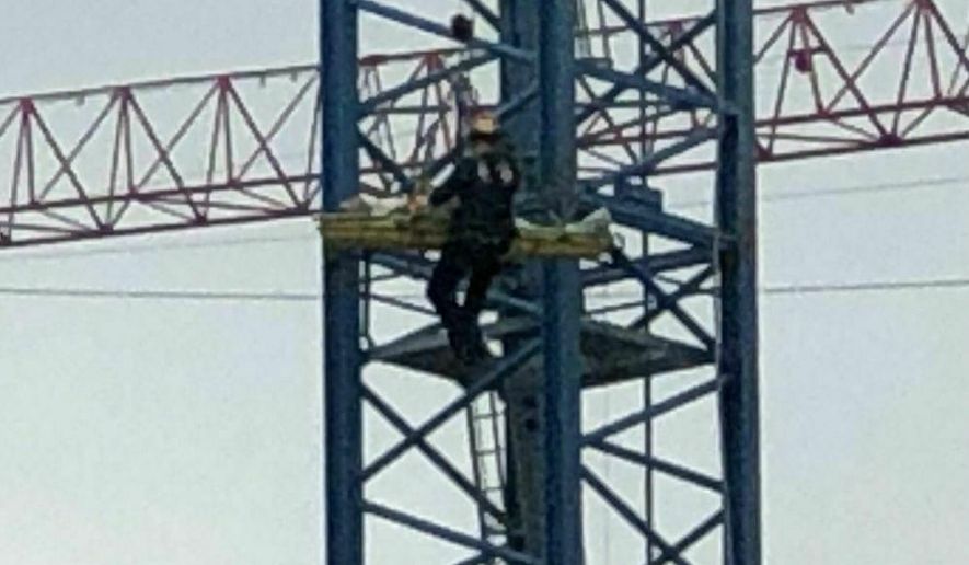 In this image take from video, Cincinnati Fire Department rescue a worker after his arm was partially severed in an accident nearly 300 feet up in the air, Friday, April 5, 2019, in Cincinnati. A fire official says the crane operator made the call after a cable sliced underneath his arm. (WCPO via AP)