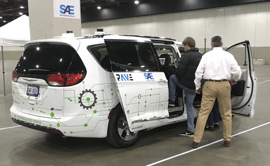 A person gets into a self-driving Chrysler Pacifica Hybrid Friday, April 5, 2019, in Detroit. Hundreds from the general public are signed up for the six-minute journey that leads riders through a course set up inside a Detroit convention center, as part of an effort to clear up misunderstandings and confusion about the technology. (AP Photo/Mike Householder)