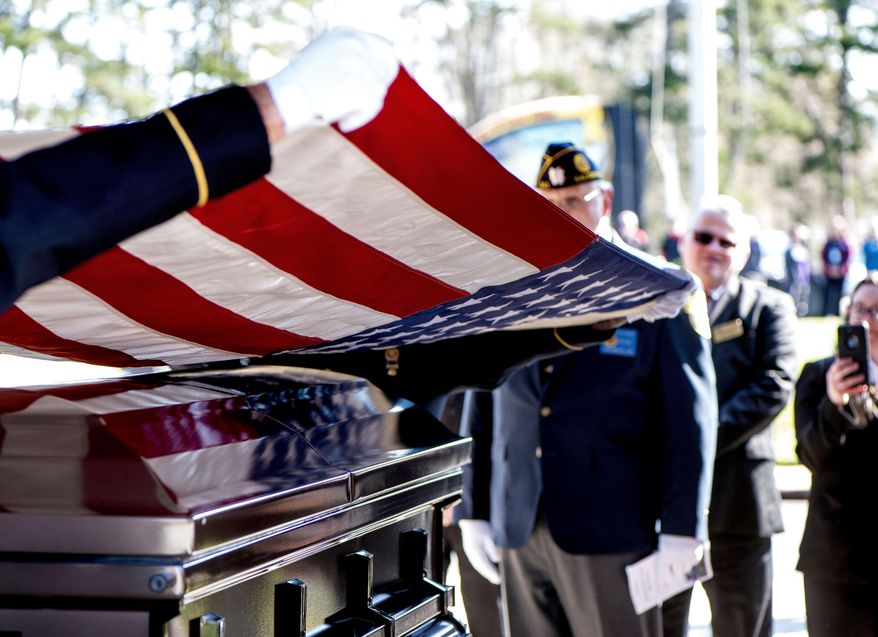 This photo taken April 3, 2019, shows members of the US Army honor guard lifting the American flag off the casket during the burial ceremony at the Salisbury National Cemetery in Salisbury, N.C. US Army medic Phillip Kenneth Drye, a veteran of the Vietnam War, was buried at the Salisbury National Cemetery on Wednesday morning with full military honors. Drye passed away on Dec. 24, 2018, but had no relatives to claim the body and pay for his funeral. (Jon C Lackey/The Salisbury Post via AP)