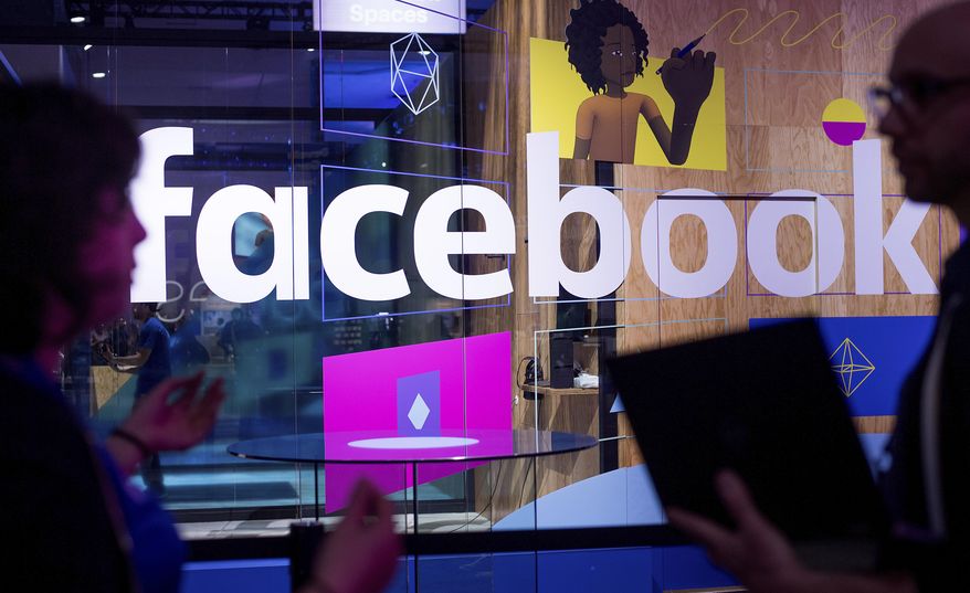In this April 18, 2017, file photo, conference workers speak in front of a demo booth at Facebook's annual F8 developer conference, in San Jose, Calif. The U.K. for the first time on Monday, April 8, 2019, proposed direct regulation of social media companies, with senior executives potentially facing fines if they fail to block damaging content such as terrorist propaganda or images of child abuse. (AP Photo/Noah Berger, File)