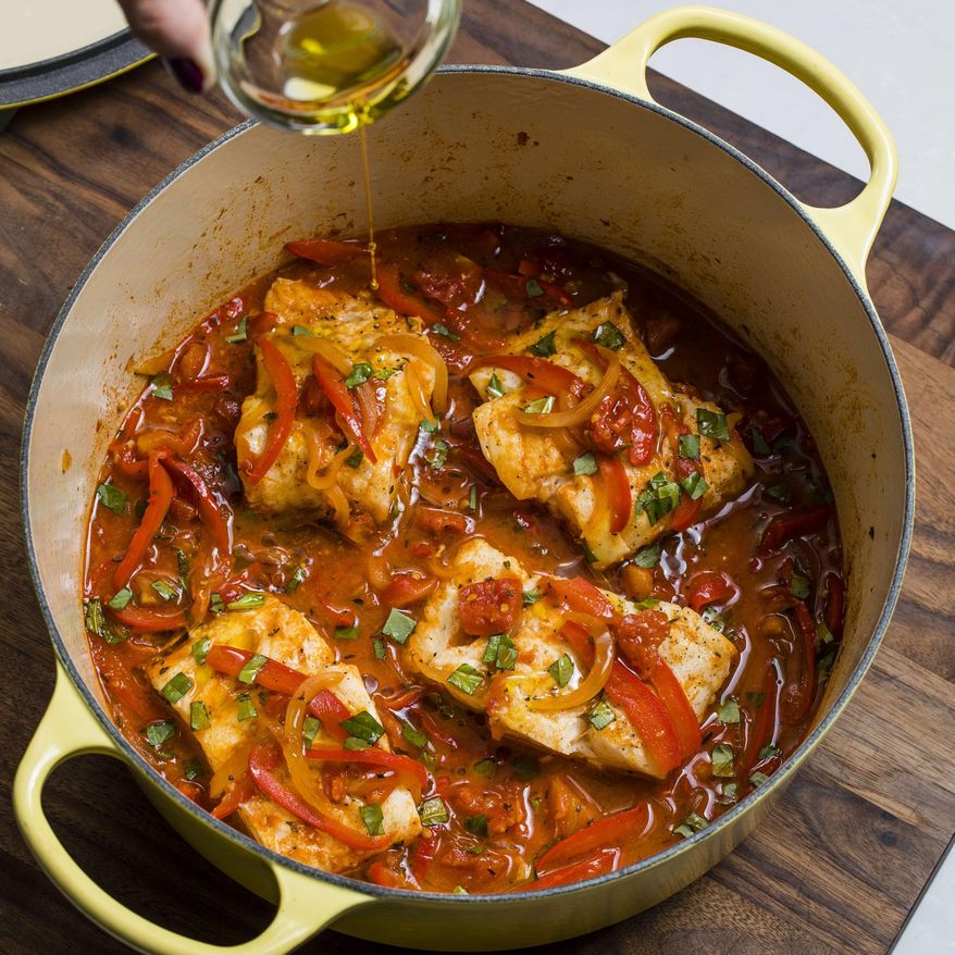 This undated photo provided by America's Test Kitchen in March 2019 shows Braised Cod Peperonata in Brookline, Mass. This recipe appears in the book "Cook It in Your Dutch Oven." (Steve Klise/America's Test Kitchen via AP)