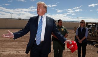 President Donald Trump visits a new section of the border wall with Mexico in Calexico, Calif., Friday April 5, 2019. Gloria Chavez with the U.S. Border Patrol, center, and Homeland Security Secretary Kirstjen Nielsen listen. (AP Photo/Jacquelyn Martin)