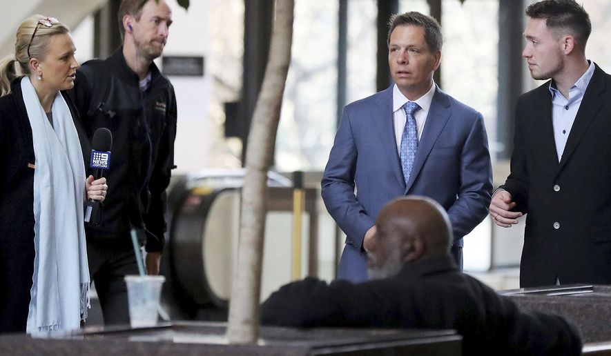 CORRECTS THAT DON DAMOND WAS JUSTINE RUSZCZYK'S FIANCE, NOT HUSBAND AND THAT ZACH DAMOND IS NOT RUSZCZYK'S SON - Media members approach Don Damond, the fiance of Justine Ruszczyk Damond, second from right, and Zach Damond, right, Don Damond's son, as they arrive for the opening arguments in the trial of former Minneapolis police officer Mohamed Noor at the Hennepin County Government Center for Tuesday, April 9, 2019, in Minneapolis. (David Joles/Star Tribune via AP)